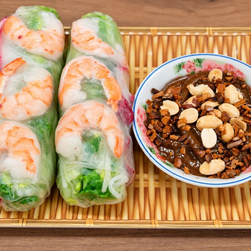 Fresh shrimp spring rolls on a bamboo tray with peanut sauce